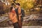 Photo of positive couple go in weekend fall outside park forest speak wear october rucksack yellow coats