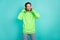 Photo of positive curious guy look empty space shopping sale concept wear green hoodie isolated teal color background