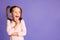 Photo of positive cute lovely schoolchild look dreamy empty space hold finger cheek isolated on violet color background