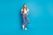 Photo of positive girl stand look in camera  blue color background