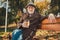 Photo of positive old man rest relax october fall weekend park pause sit bench enjoy aromatic takeaway coffee mug wear