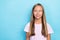 Photo of positive optimistic small girl with straight hairdo dressed pink t-shirt look empty space isolated on blue