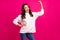 Photo of power feminist lady raise hand show biceps wear white hoodie isolated pink color background