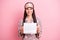 Photo of pretty charming young woman sleepwear holding paper calendar isolated pink color background