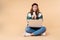 Photo of pretty clever woman holding credit card while sitting on floor