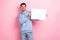 Photo of pretty cool guy dressed blue sweatshirt rising white poster empty space isolated pink color background