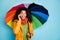 Photo of pretty dark skin lady hold colorful umbrella telephone speaking friends listen awesome news wear stylish