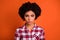 Photo of pretty doubtful lady dressed checkered shirt rising brow looking you isolated orange color background