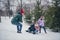 Photo of pretty funky little child wife husband dressed coats sledding having fun together outdoors urban forest park