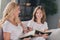 Photo of pretty funny daughter mom wear white t-shirts smiling reading novels sitting sofa indoors inside room home