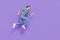 Photo of pretty handsome guy dressed grey shirt jumping high running fast empty space isolated purple color background