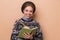 Photo of pretty happy woman in earrings making notes in diary