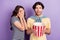 Photo of pretty impressed lovers dressed casual outfit arm close eyes eating pop corn smiling isolated purple color