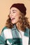 Photo of pretty joyful woman in knit hat laughing and looking aside