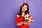 Photo of pretty lady holding big tulips bunch hands wear red dress isolated purple background