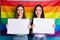 Photo of pretty lesbians couple ladies parade tolerance same sex marriages stand in front of gay rainbow flag background