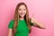 Photo of pretty satisfied girl wear green stylish clothes thumb up cool offer proposition empty space isolated on pink