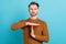 Photo of pretty serious young guy dressed knit sweater showing time out gesture isolated blue color background