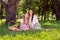 Photo of pretty shiny mother daughter wear casual clothes smiling having picnic sitting plaid blanket outdoors urban