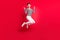 Photo of pretty sweet woman dressed striped outfit earphones jumping pointing fingers empty space isolated red color