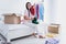 Photo of pretty sweet young lady sleepwear sitting bed putting clothes paper boxes indoors room home