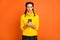 Photo of pretty young person look hands hold phone wear knitter sweater isolated on orange color background