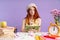 Photo of puzzled student girl writing in exercise book while doing homework