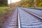 Photo of the railway. Steel rails, concrete sleepers, gravel filling. Autumn urban landscape. Railway landscape