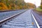 Photo of the railway. Steel rails, concrete sleepers, gravel filling. Autumn urban landscape. Railway landscape