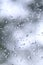 A photo of rain drops on the window glass with a blurred view of the blossoming green trees. Abstract image showing cloudy and ra