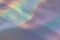Photo of a real bright rainbow crumpled holographic background with a skin texture with rays daylight