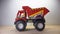 Photo of red dirt truck toy car  on wooden base