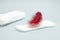 A photo of red feather flying above the menstrual sanitary daily woman pad. Hygiene conceptual photo. Woman critical days, menstru