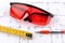 Photo red protective spectacles and red pen and measuring tape