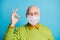 Photo of retired grandpa raise hand fingers showing okey wear white face mask isolated blue color background