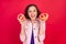 Photo of retired mature lady hold two grapefruit slice beaming smile wear pink jacket isolated red color background