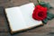 Photo Romantic ambiance present, red rose, and notebook on wood