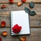 Photo Romantic ambiance present, red rose, and notebook on wood