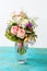 Photo of romantic bouquet of pink roses, lilies, green leaves in vase .