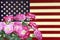 A photo of roses on the USA flag. American flag in vintage style and flowers for the Memorial Day or 4th of July.
