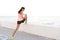 Photo of runner woman 20s in tracksuit stretching legs, during d