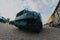 Photo of a Russian green armored car on a caterpillar track among the railway trains. Strong distortion from the fisheye len