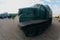 Photo of a Russian green armored car on a caterpillar track among the railway trains. Strong distortion from the fisheye len