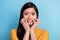 Photo of scared millennial brunette lady bite hands wear yellow shirt isolated on blue color background