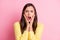 Photo of scared terrified young woman dressed casual clothes open mouth arms cheeks  pastel pink color