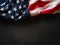 In the photo we see the American state flag. Symbolizes freedom and patriotism. Dark gray background. Minimalism. There is an