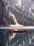 Photo of a serene boat floating on a picturesque lake with a majestic mountain backdrop