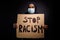 Photo of serious afro american guy hold card board banner stop racism share message human equality wear jumper medical