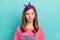 Photo of serious brown hairdo small girl wear headband pink t-shirt isolated on teal color background