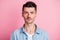 Photo of serious brown haired young handsome man wear blue shirt isolated on pastel pink color background